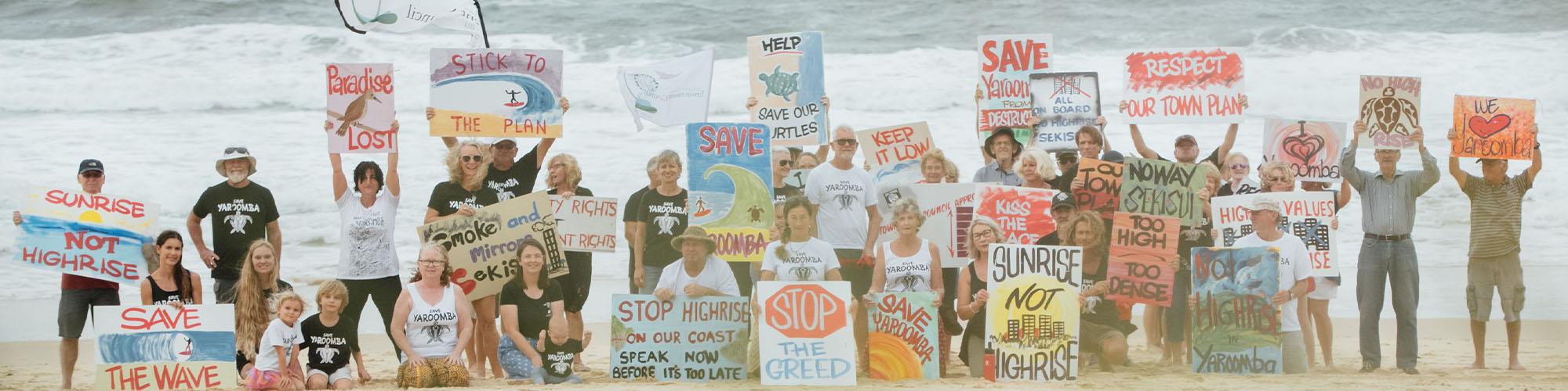 group of people holding signs on beach