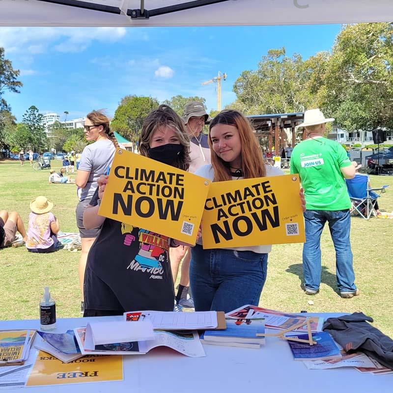 two girls holding signs about climate action